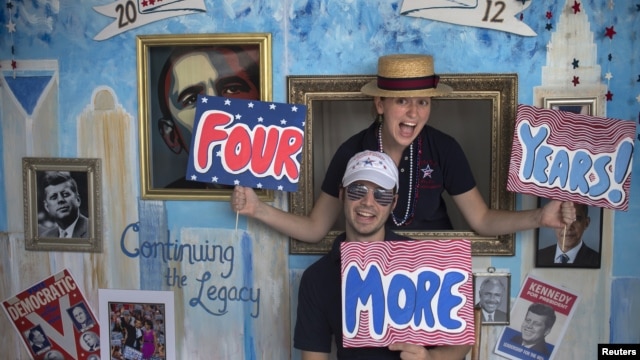 Stephen Kimel and his wife Greta Kimel attract costumers to take pictures at their photo booth which was set-up at a street festival for convention goers ahead of the Democratic National Convention in Charlotte, North Carolina, September 3, 2012.  