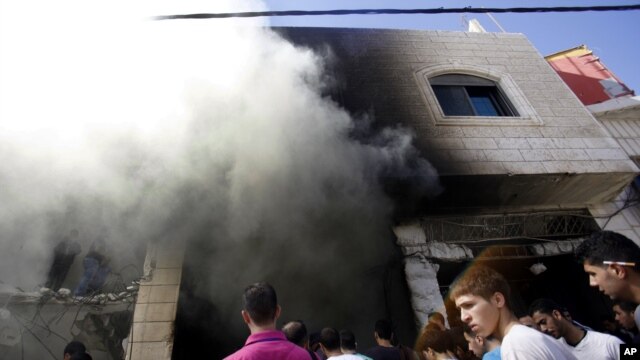 Người Palestine vây quanh hiện trường sau khi quân đội Israel bắn chết 2 nghi can Palestine, Abu Amer Aisheh và Marwan Qawasmeh, ở Bờ Tây Hebron, ngày 23/9/2014.