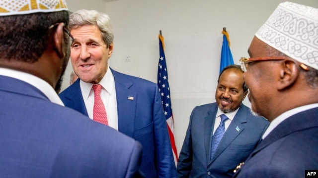 U.S. Secretary of State John Kerry, in red tie, meets with Somalia's President Hassan Sheikh Mohammed, in blue tie, and Somali regional leaders at the Mogadishu airport, May 5, 2015.