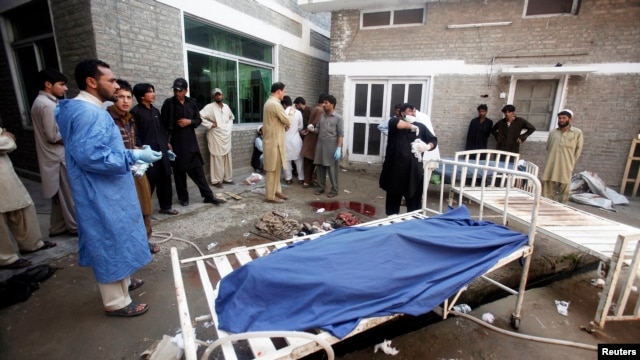 Relatives stand next to the body of a man in Lady Reading Hospital in Peshawar, March 21, 2013.