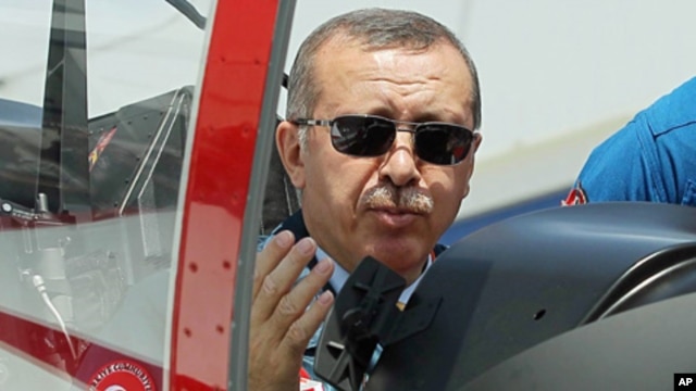 Turkish Prime Minister Recep Tayyip Erdogan in the cockpit of Hurkus (Freebird), Turkey's first locally produced military training plane, outside Ankara, Turkey, June 27, 2012 (AP).