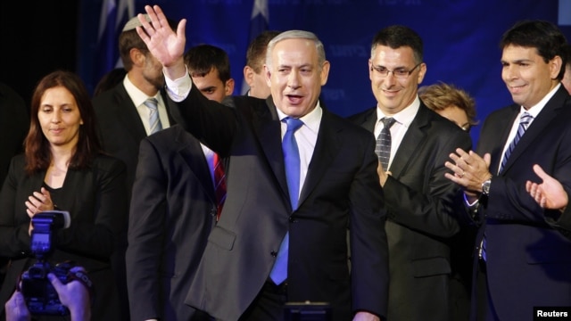 Israel's Prime Minister Benjamin Netanyahu waves to supporters as he stands with his party members at the Likud-Yisrael Beitenu headquarters in Tel Aviv January 23, 2013.