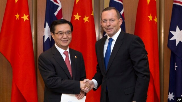 Thủ tướng Australia Tony Abbott và Bộ trưởng Thương mại Trung Quốc Cao Hổ Thành dự lễ ký kết hôm nay tại Canberra, ngày 17/6/2015.
