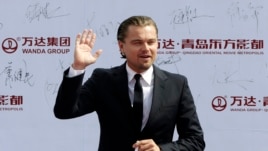 Diễn viên điện ảnh Leonardo DiCaprio chào giới truyền thông và các fan khi đến dự buổi lễ ở Thanh Đảo 22/9/13