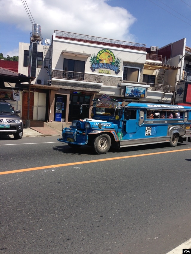 A jeepney drives through Barrio Barretto, Oct. 22, 2015. (R. Jennings/VOA)