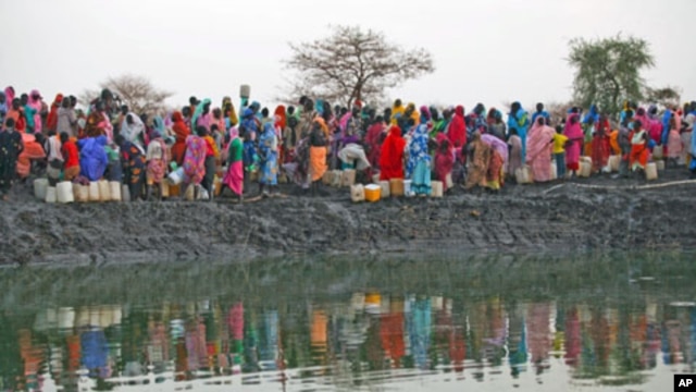Displaced women gather to collect water from a water hole near Jamam refugee camp in South Sudan's Upper Nile State, March 10, 2012.