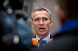 NATO Secretary General Jens Stoltenberg speaks with the media as he arrives for a meeting with European Union defense ministers at the EU Council building in Brussels, Nov. 18, 2014.