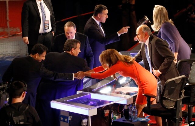 Bobby Jindal, left, Chris Christie, Mike Huckabee and Rick Santorum talk to moderators Trish Regan, Gerald Seib and Sandra Smith, right, after a Republican presidential debate at Milwaukee Theatre, Tuesday, Nov. 10, 2015, in Milwaukee.