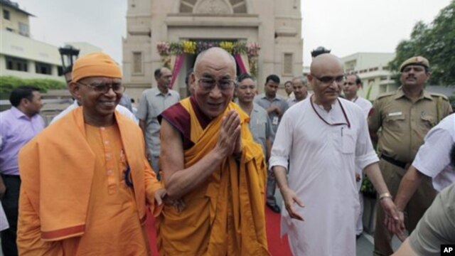 Tibetan spiritual leader the Dalai Lama, center, gestures as he leaves after attending an all faith prayer service for world peace and harmony organized by the Ramakrishna Mission in New Delhi, India, Tuesday, Sept. 11, 2012. (AP Photo/Altaf Qadri)