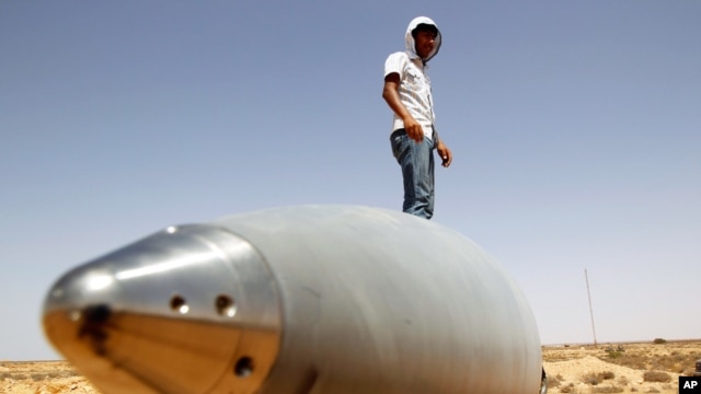 An anti-Gaddafi fighter stands on an SA-5 SAM missile in Burkan air defense military base, which was destroyed by a NATO air strike in August, 2011.