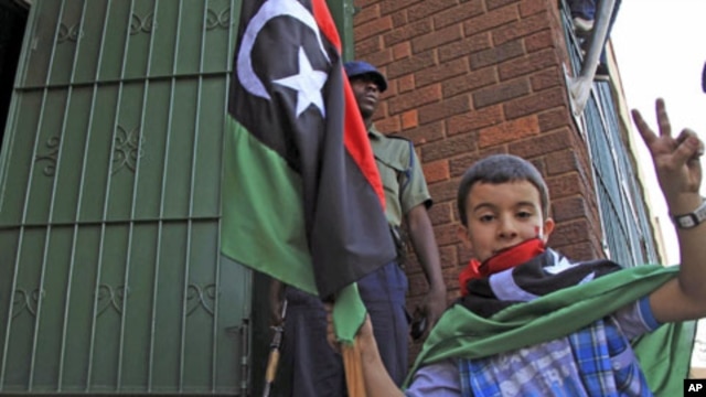 A child holds a Kingdom of Libya flag as a group of Libyans living in Zimbabwe demonstrate outside the Libyan embassy in the capital of Harare,  August 24, 2011 (file photo)