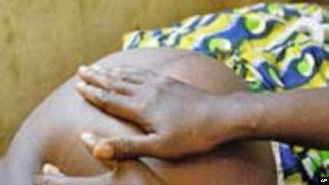 A maternal and child health aid examines an expectant mother at a local clinic in Sierra Leone