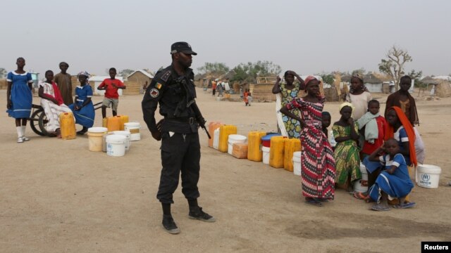 FILE - A Cameroonian police officer enforces order in Minawao, Cameroon, March 15, 2016.