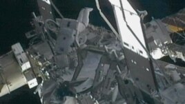 Space station commander Sunita Williams (C) works on a leaky radiator system just hours after being hit by a piece of orbiting debris, outside the International Space Station, November 1, 2012.