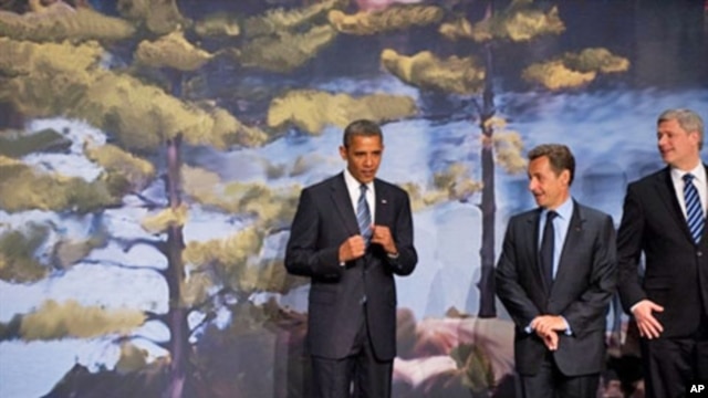 US President Barack Obama gestures alongside French President Nicolas Sarkozy and Canadian Prime Minister Stephen Harper at the Deerhurst Resort at Muskoka, in Huntsville, Ontario, Canada, 25 Jun 2010