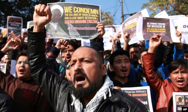 FILE - Muslims students carry placards and shout slogans against the Nigerian government after the killings of hundreds of Shi'ite Muslims and the detaining of their leader Ibraheem Zakzaky in Nigeria, in Jammu, India, Dec. 15, 2015.