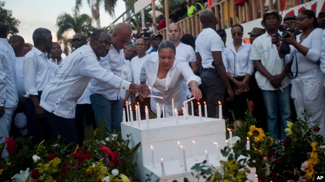 Haiti's new Prime Minister Evans Paul, left center, Haiti's President Michel Martelly, center, and first lady Sophia Martelly, lead a vigil at the site of a high-voltage wires' accident that left at least 16 people dead, in Port-au-Prince, Haiti, Feb. 17,