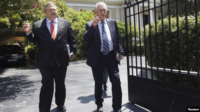 Leader of Greece's Panhellenic Socialist Movement party Evangelos Venizelos (L) and leader of the Democratic Left party Fotis Kouvelis leave the prime minister's office after a meeting in Athens, July 18, 2012. 