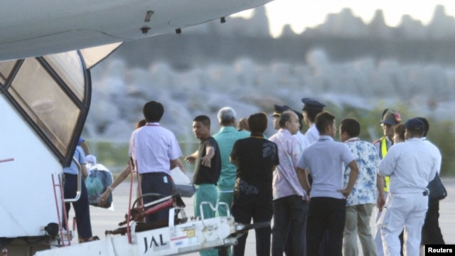 Chinese activists detained after landing on a disputed island are escorted by airport officials as they board a flight to Hong Kong, in this photo taken by Kyodo August 17, 2012. 