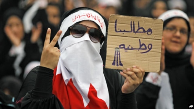 A Bahraini female Shi'ite protester holds a sign reading: "our demands are for country" during a rally in the village of Diraz, West of Manam, July 1, 2011