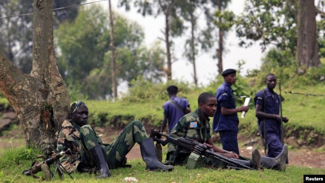 M23 rebel fighters guard the venue of a news conference by political leader Jean-Marie Runiga in north Kivu province near the border with Uganda, July 21, 2012.