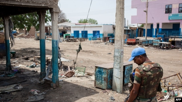 A United Nations peacekeeper looks at the destruction in downtown Malakal, South Sudan, on March 4, 2014. 