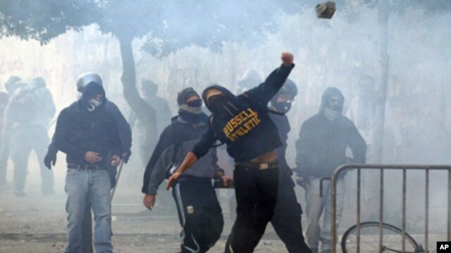 A demonstrator throws a stone during a demonstration of the 'Indignant' group in Rome October 15, 2011. Protesters worldwide geared up for a cry of rage on Saturday against bankers, financiers and politicians they accuse of ruining global economies and co