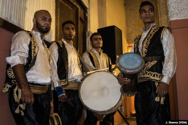 A group of drummers wait in the wings.