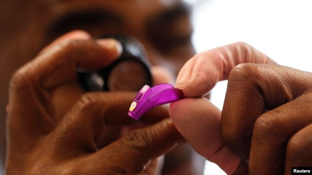 A technician adjusts the controls on a hearing device (file photo).