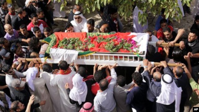 Bahraini mourners march in funeral procession in the western village of Karzakan, Bahrain, carrying the body of Isa Abdel Hasan, who died Thursday during clashes in Pearl Square in the capital of Manama, February 18, 2011