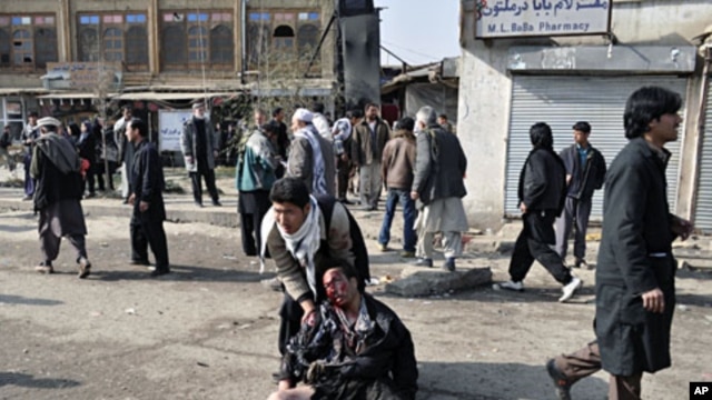 A wounded man is being helped after a suicide blast targeting a Shi'ite Muslim gathering in Kabul December 6, 2011