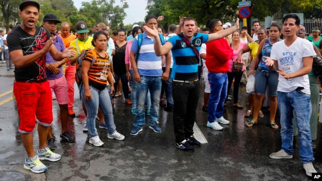 Cubans disrupt traffic on a street near Ecuador's embassy, expressing discontent with new rules requiring Cubans to have a visa to visit the South American country, in Havana, Cuba, Nov. 28, 2015.