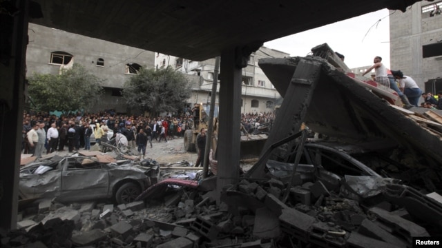 Warga Palestina mengamati rumah pegawai Hamas yang hancur terkena serangan udara Israel di Jabalya, utara jalur Gaza (17/11). Serangan udara Israel menarget gedung-gedung pemerintah Hamas, termasuk Markas Besar Kabinet  Hamas di wilayah ini.