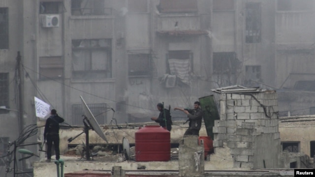Tentara Pembebasan Suriah mengibarkan bendera Islam di sebuah atap pasca pertempuran hebat melawan pasukan pendukung Presiden Bashar al-Asaad di wilayah Jobar, Damascus, Suriah (6/2).