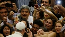 Pope Francis is cheered by faithful as he arrives in the Paul VI hall at the Vatican, Aug. 5, 2015.