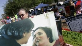 A supporter holds a large photo of Terri Schiavo in Pinellas Park, Fla. in 2005