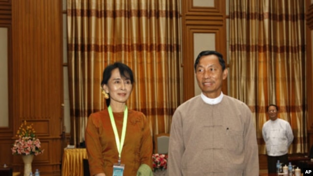 Burma's pro-democracy leader Aung San Suu Kyi (L) poses with Lower House Parliamentary Speaker Shwe Man during her visit to the parliament in the capital Naypyitaw, December 23, 2011.
