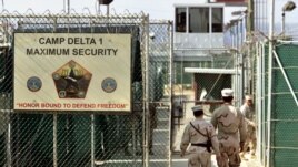 US military guards walk within Camp Delta military-run prison, at the Guantanamo Bay US Naval Base, Cuba, June 27, 2006.