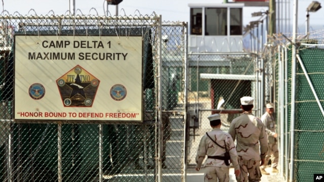 US military guards walk within Camp Delta military-run prison, at the Guantanamo Bay US Naval Base, Cuba, June 27, 2006.