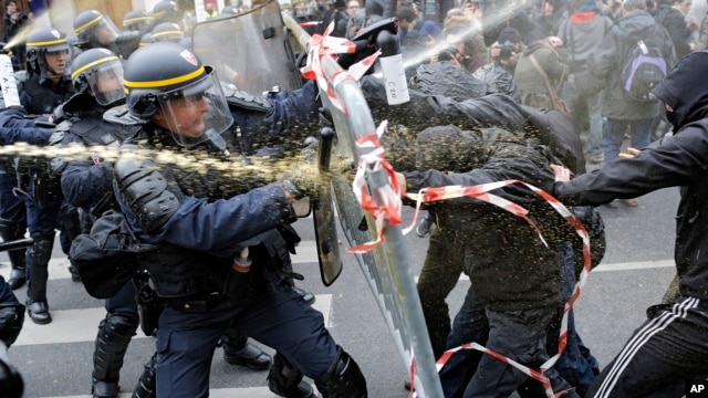 Policías antidisturbios luchan con manifestantes que piden un acuerdo para detener el cambio climático, en la Plaza de la República en París, un día antes de la Cumbre del Clima de la ONU.
