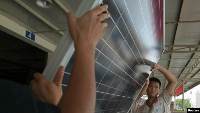 FILE - Employees examine newly-made solar panels before boxing for shipment at a factory of Yingli Solar in Baoding, Hebei province, August 2, 2012.