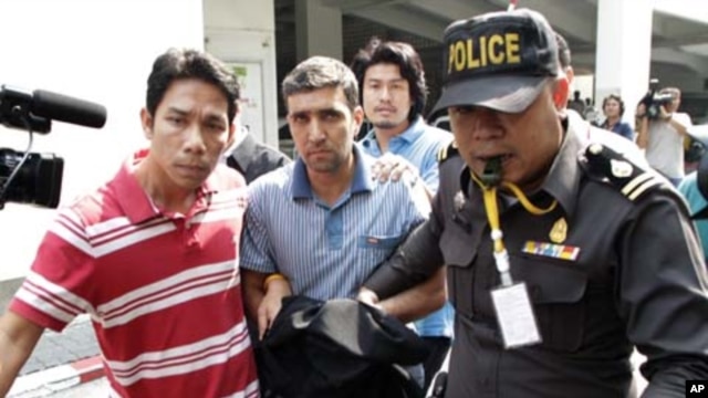 Thai police officers escort  Iranian suspect Mohammad Khazaei (C) at the Immigration Bureau in Bangkok February 16, 2012.