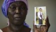 FILE - Martha Mark, mother of kidnapped schoolgirl Monica Mark, cries as she displays her photo in the family's house in Chibok, Nigeria, May 19, 2014