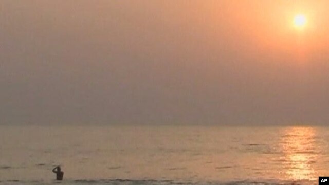 A tourist wades in the water at a beach in Sierra Leone