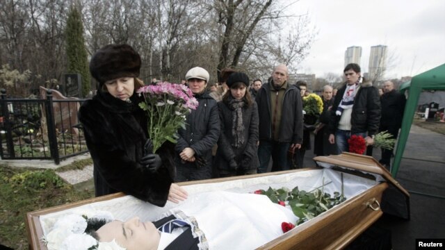 Bà Nataliya Magnitskaya mẹ của ông Sergei Magnitsky đứng cạnh quan tài của ông trước khi mai táng