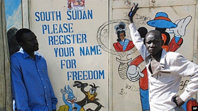 Southern Sudanese artists stand next to a painted sign in the southern capital of Juba urging people to register for the upcoming independence referendum, 30 Sep 2010