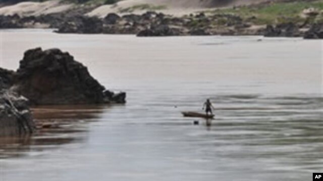 A fisherman works near the site of the proposed Xayaburi Dam in Paksey, northern Laos, file photo. 