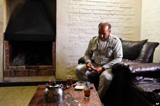 FILE - Merhi Alshebli rolls a cigarette in his living room in Juan Lacaze, Uruguay. In November 2014, locals welcomed Alshebli, his wife and their 15 children, who were fleeing Syria's civil war. The family later complained they couldn't make ends meet because of the high cost of living in Uruguay.
