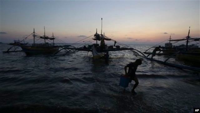 Một cậu bé người Philippines mang một cái thùng từ những tàu đánh cá mới cập bờ ở thị trấn Infanta, tỉnh Pangasinan, Philippines.