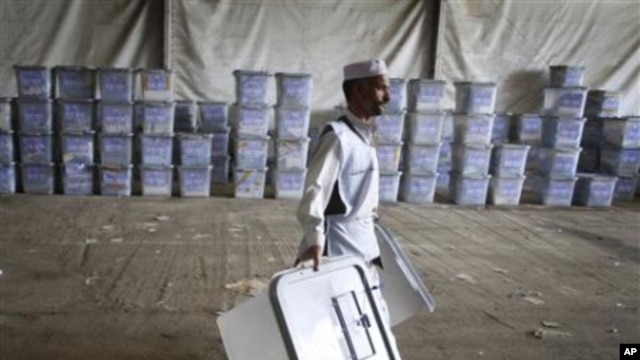 An Afghan election worker carries ballot boxes at the warehouse of Afghanistan's Independent Election Commission in Kabul, Afghanistan, a few days after parliamentary elections on September 18, 2010.